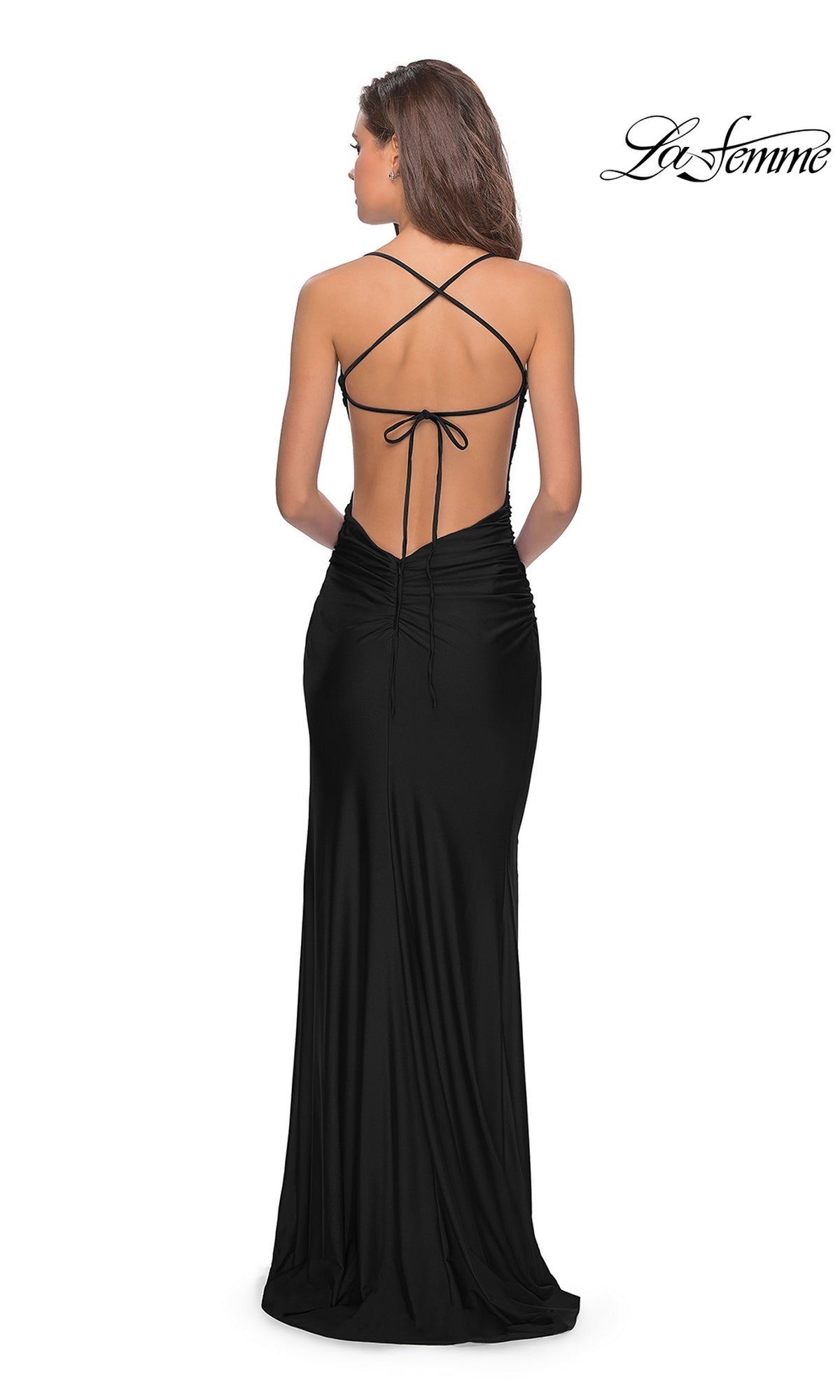 A woman wears the La Femme Open-Back Simple Long Prom Dress 30630, a black backless formal gown with thin crisscross straps and a fitted silhouette, standing against a plain white background.